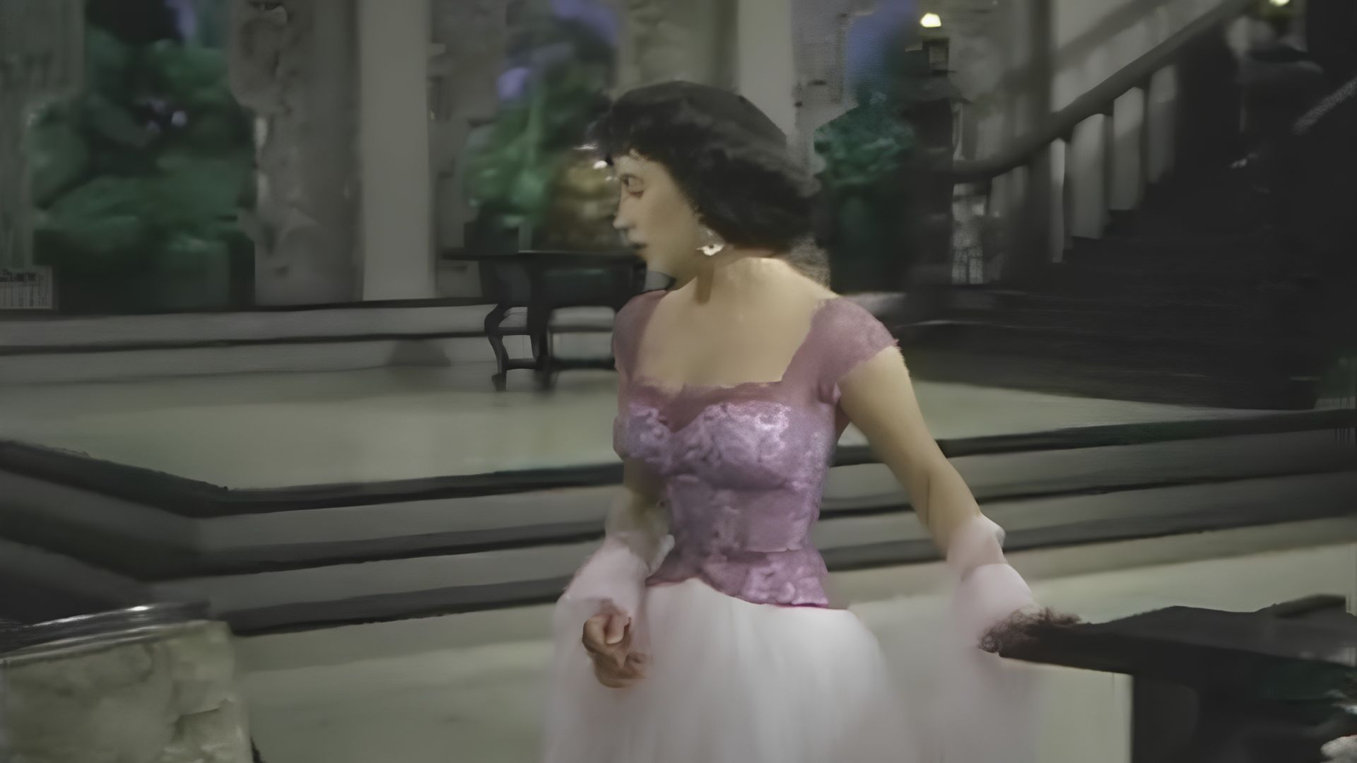Elizabeth Taylor descends a staircase in a lavender lace bodice gown with a voluminous white tulle skirt.