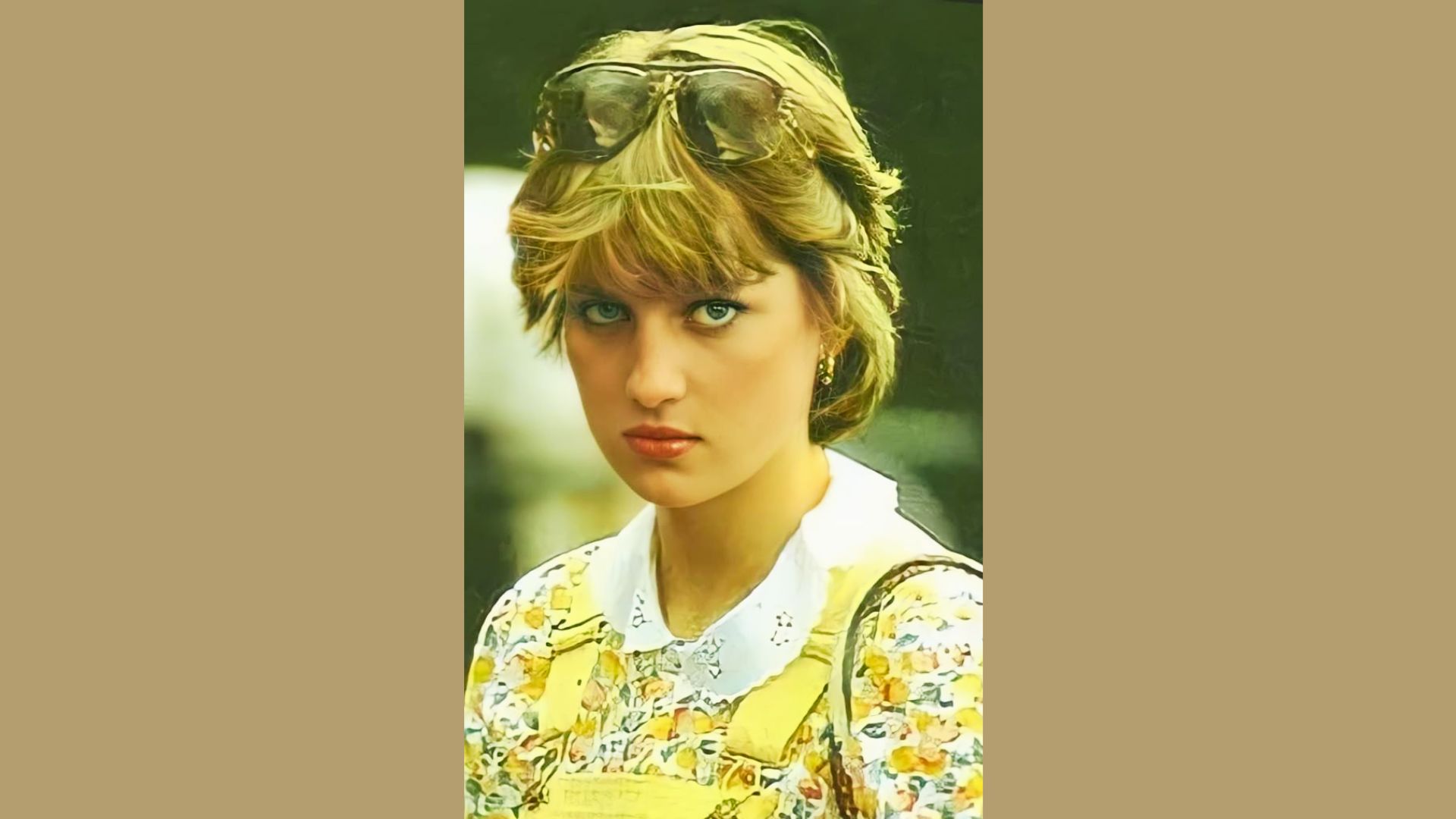 Princess Diana wears a yellow floral blouse with a white eyelet collar and sunglasses resting on her head.