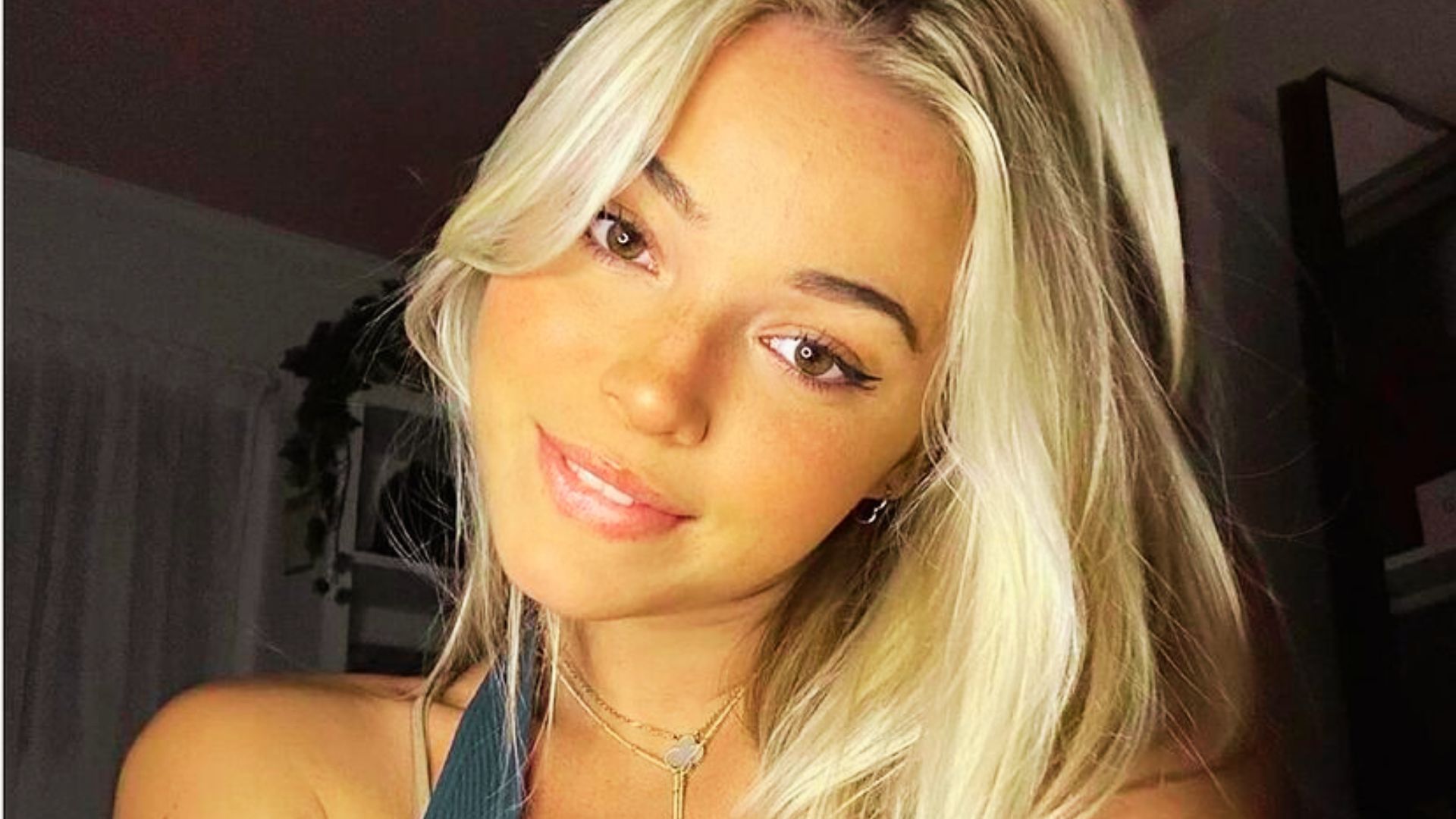 Close-up selfie of Livvy Dunne smiling at the camera with layered necklaces.