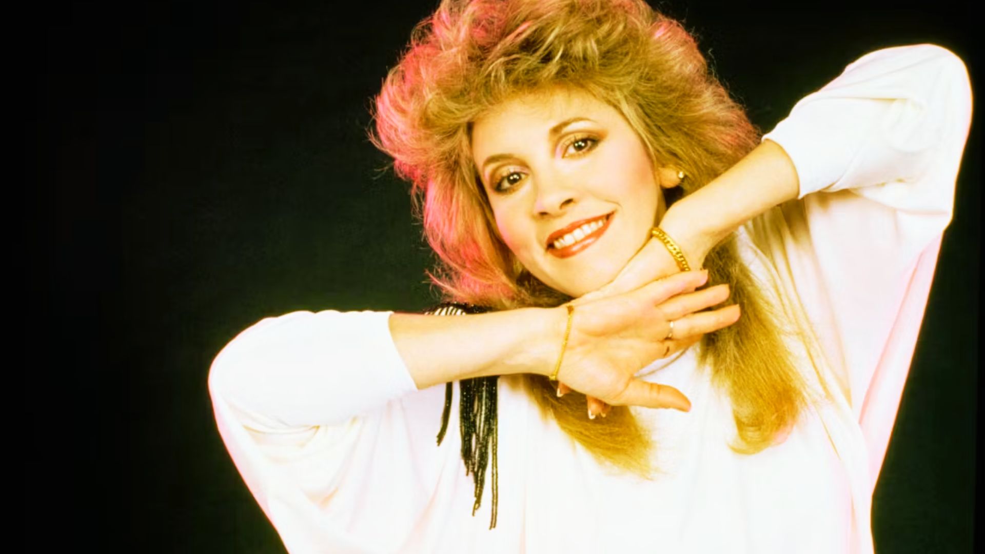 Stevie Nicks poses with her 80s perm: big, backcombed blonde hair with major volume.