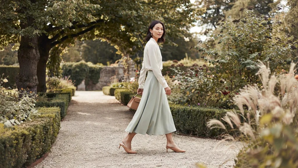 Woman wearing a midi skirt and longer top for a balanced silhouette.
