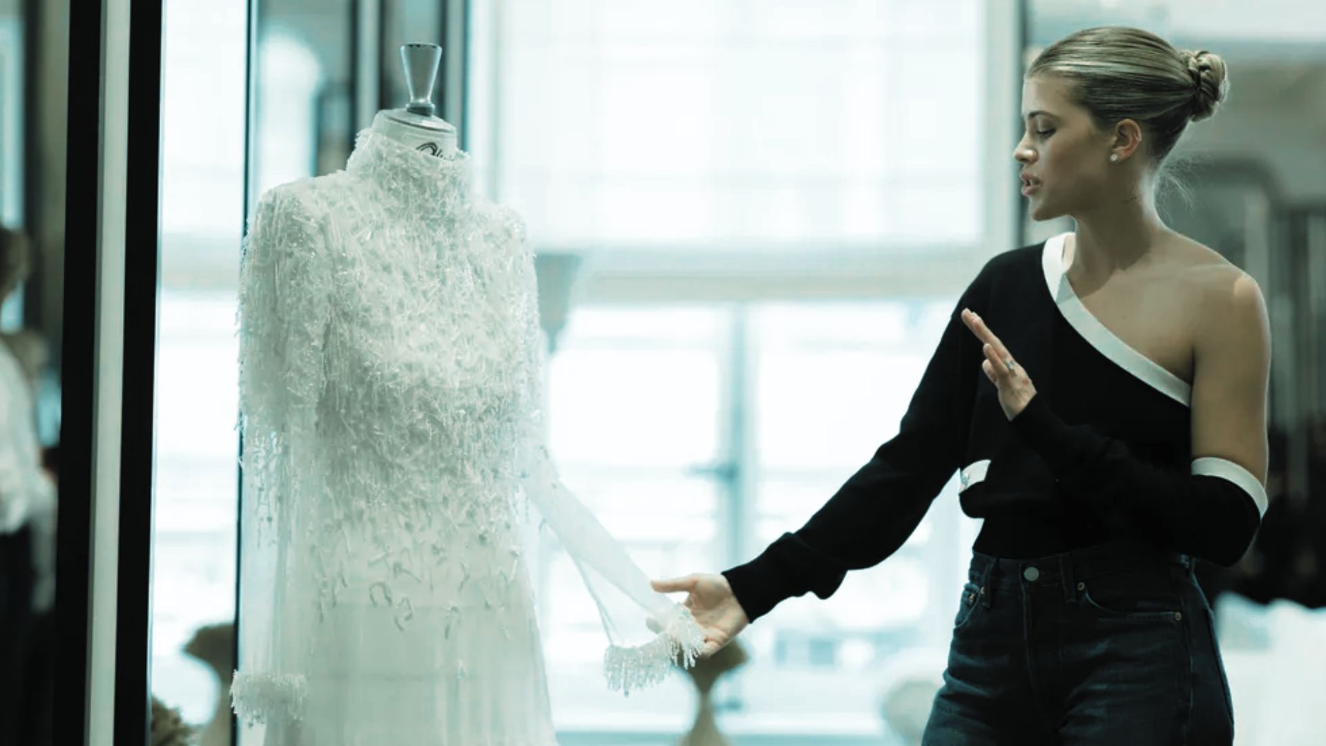 Sofia Richie reviewing her custom Chanel wedding dress on a mannequin during a fitting session in Paris.