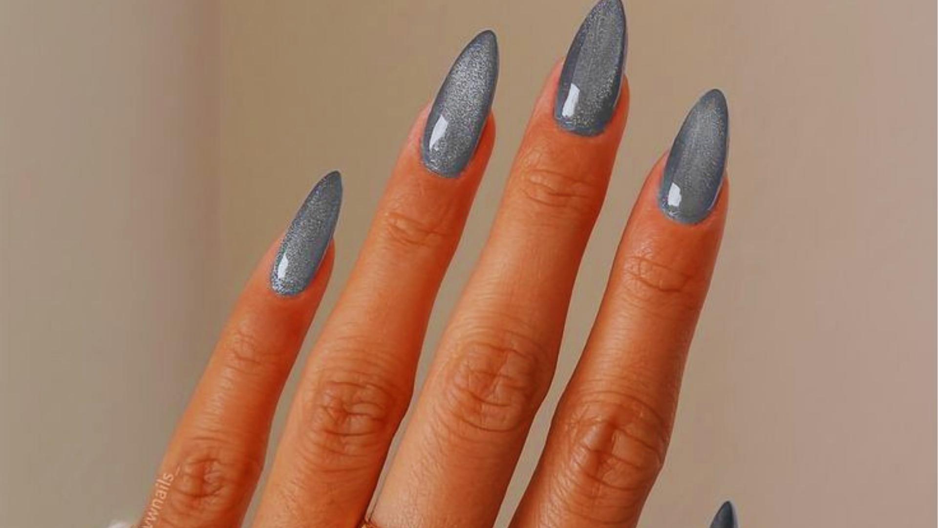 Long stiletto nails in shimmery slate gray cat-eye polish with magnetic velvet effect, a moody take on Hailey Bieber’s glazed trend.