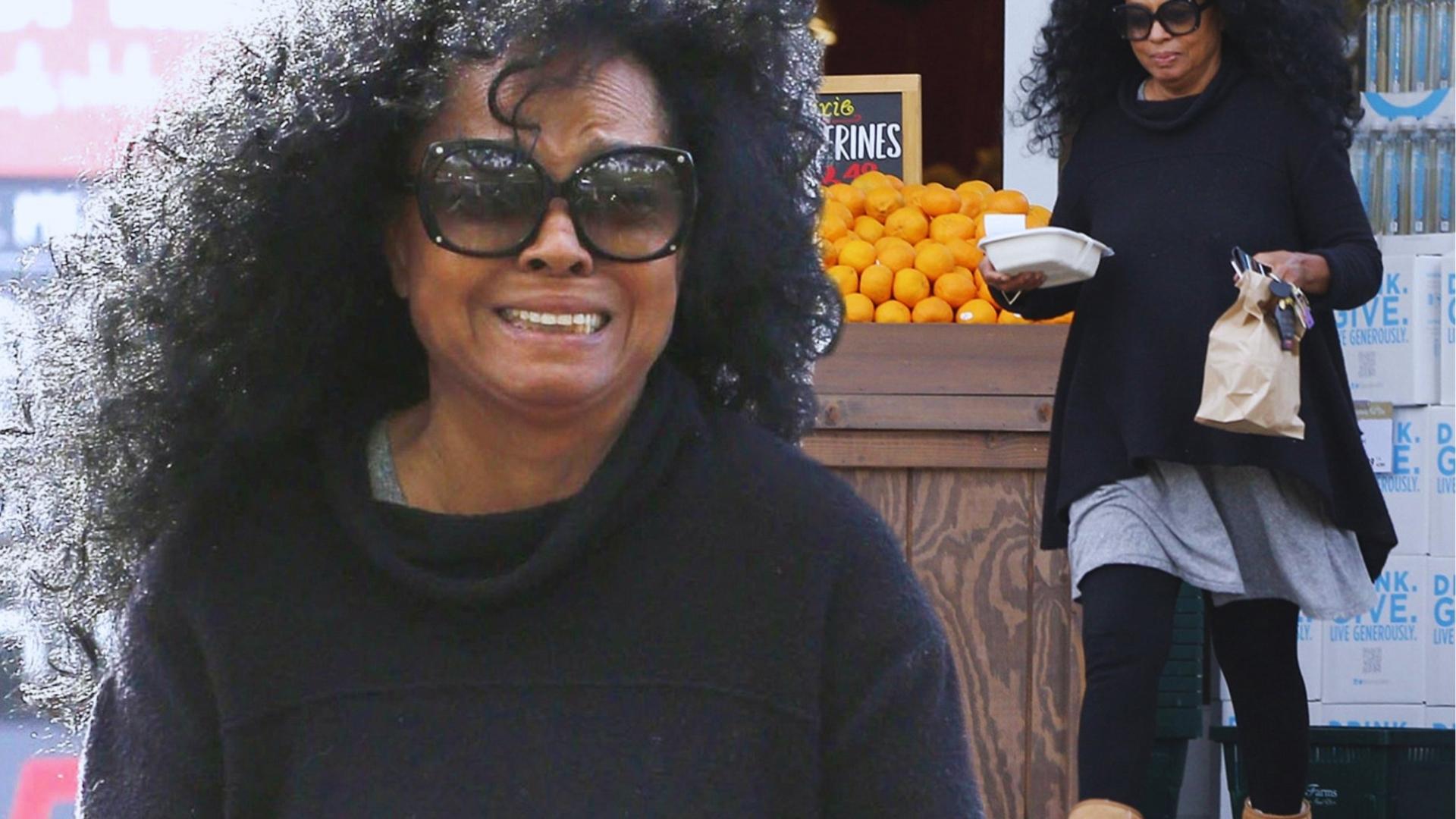 Candid Diana Ross in black sweater and oversized sunglasses smiles while shopping, showing her natural curly afro at farmers market.