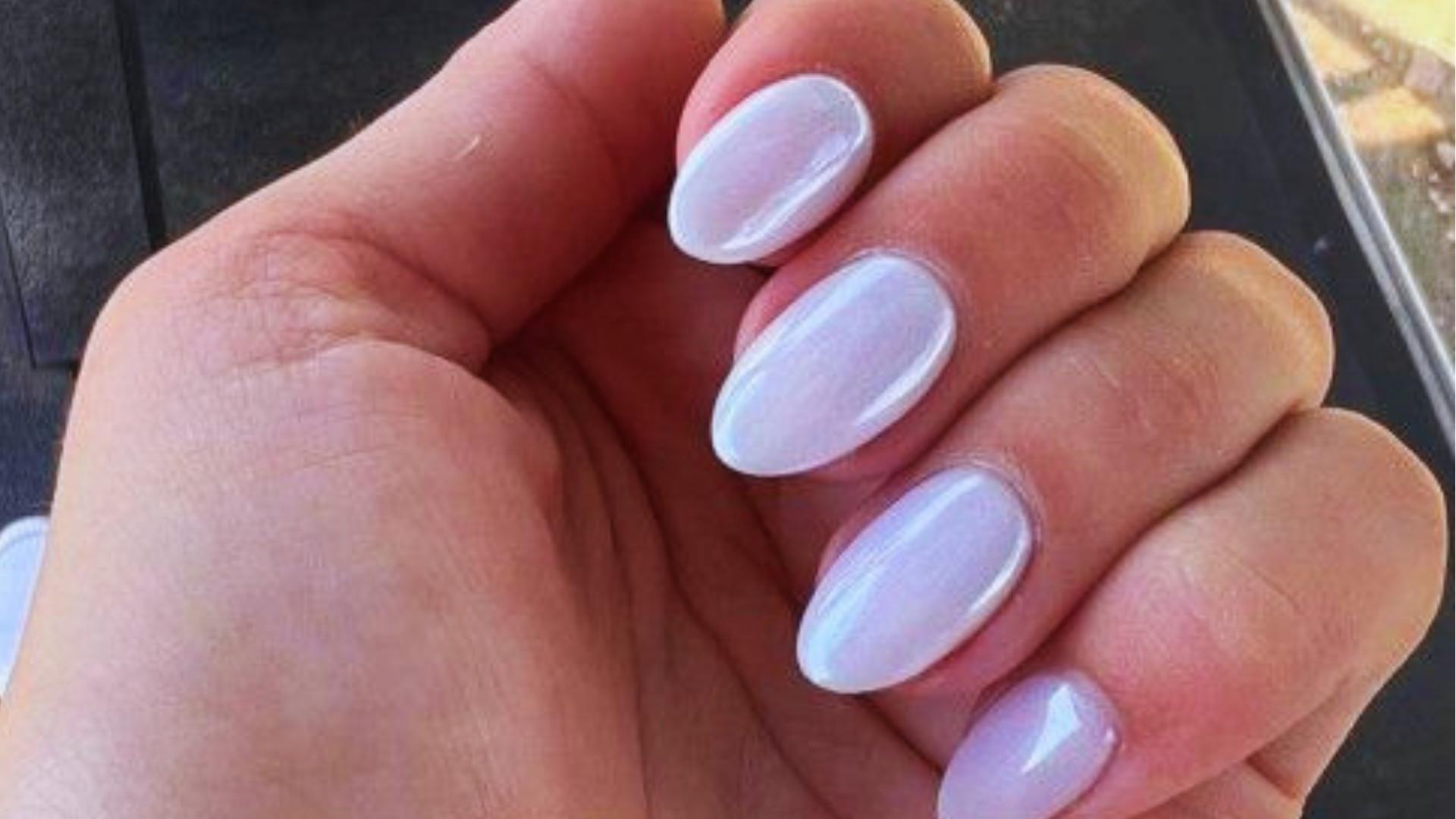 Medium almond nails in Hailey’s glazed donut style with milky white chrome finish, high-gloss pearly sheen catching sunlight.