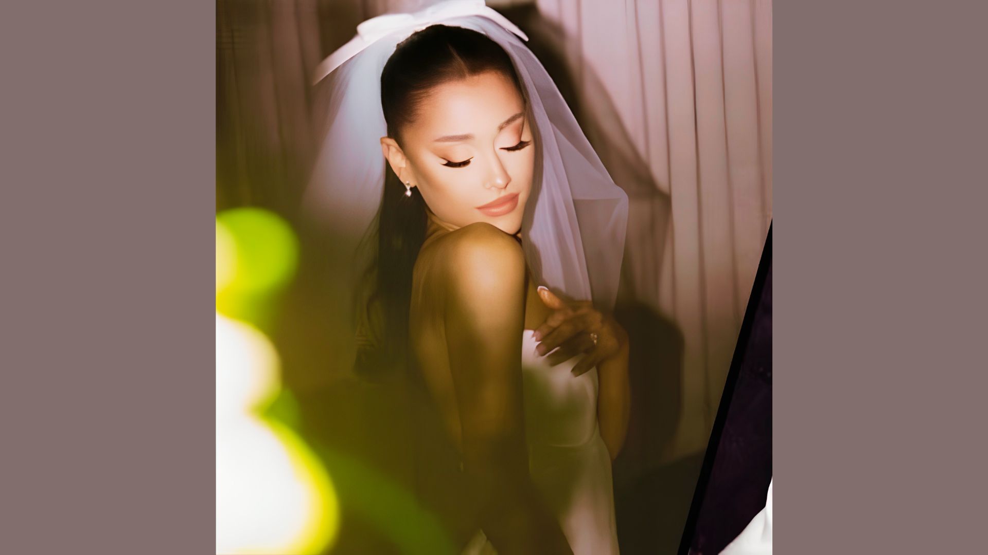 Ariana Grande wedding look featuring a silk gown, veil, and polished makeup.