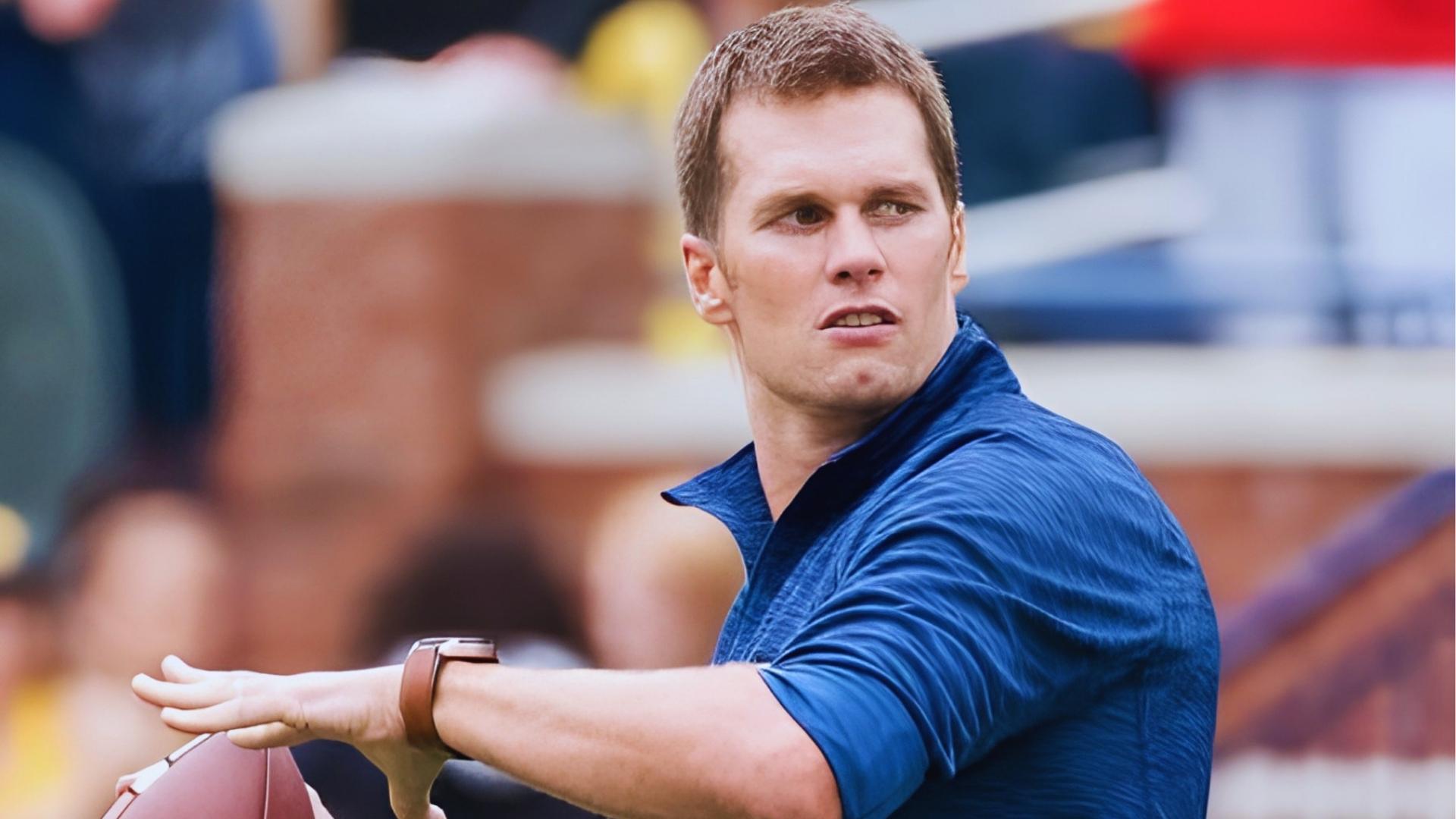 Tom Brady in blue shirt throwing ball with short cropped haircut on the sideline.