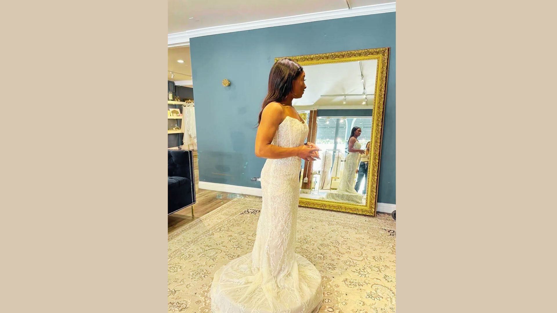 Simone Biles views herself in a gold-framed mirror during a bridal salon fitting.