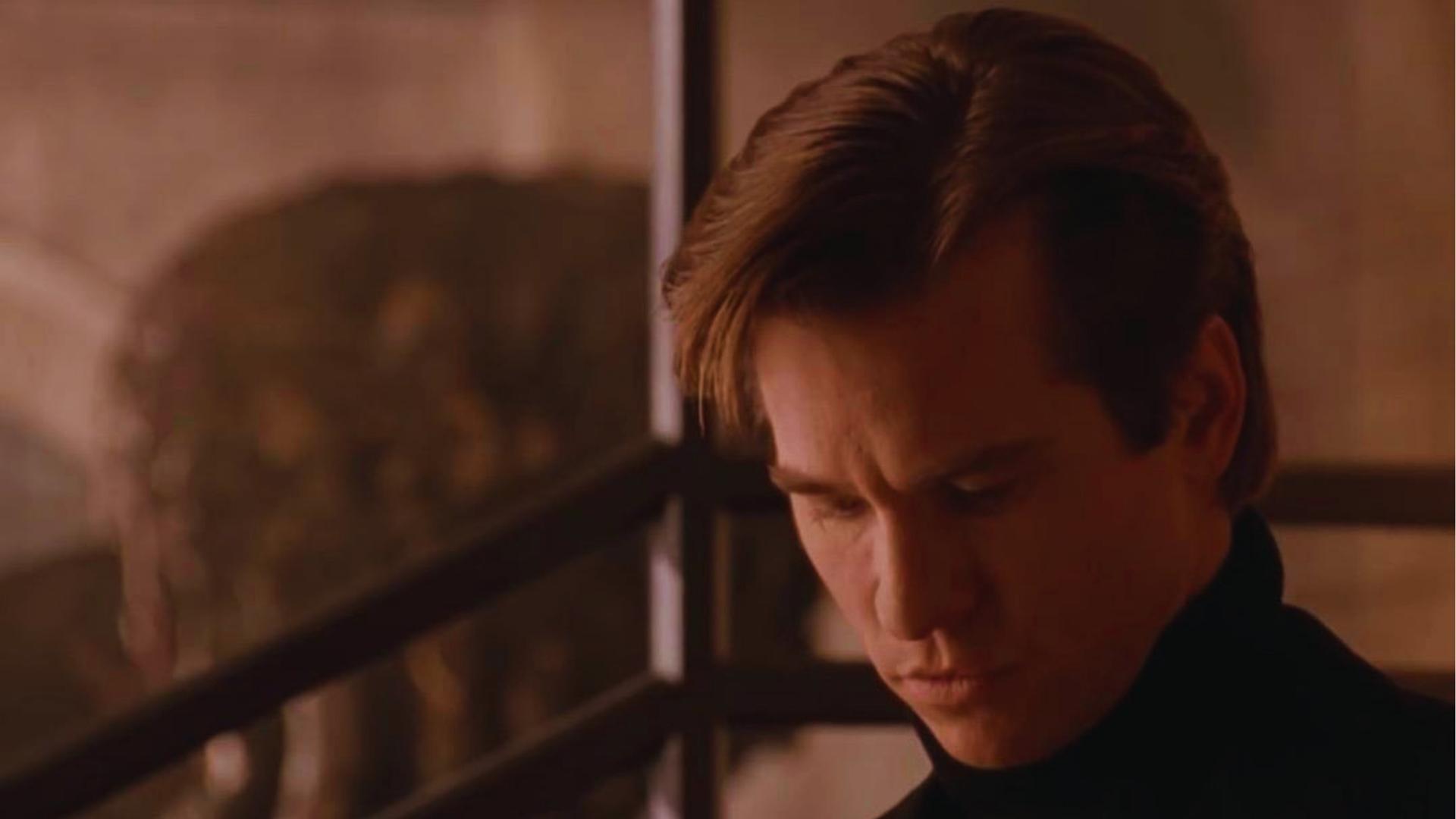 Val Kilmer as Bruce Wayne with neat side-parted blonde hair in black turtleneck in Batman Forever.