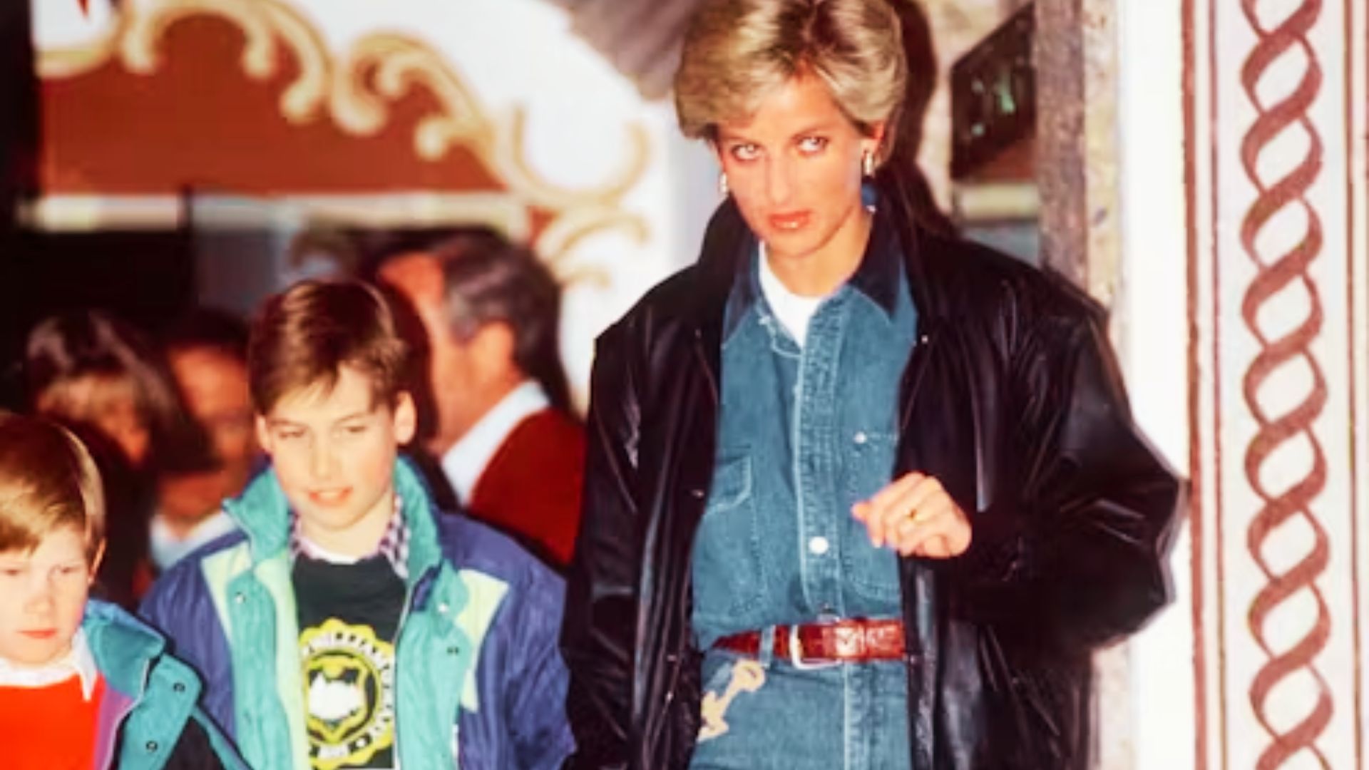 Princess Diana wears double denim with a leather jacket and brown belt while out with young Prince William and Prince Harry.