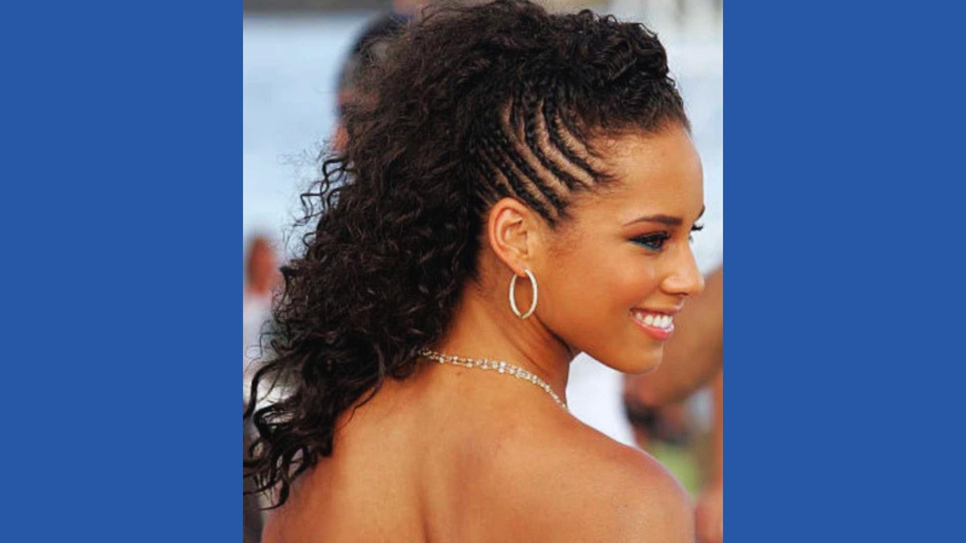 Profile of Alicia Keys with side-swept cornrows feeding into voluminous curly ponytail, silver hoops, diamond necklace, bare shoulder.