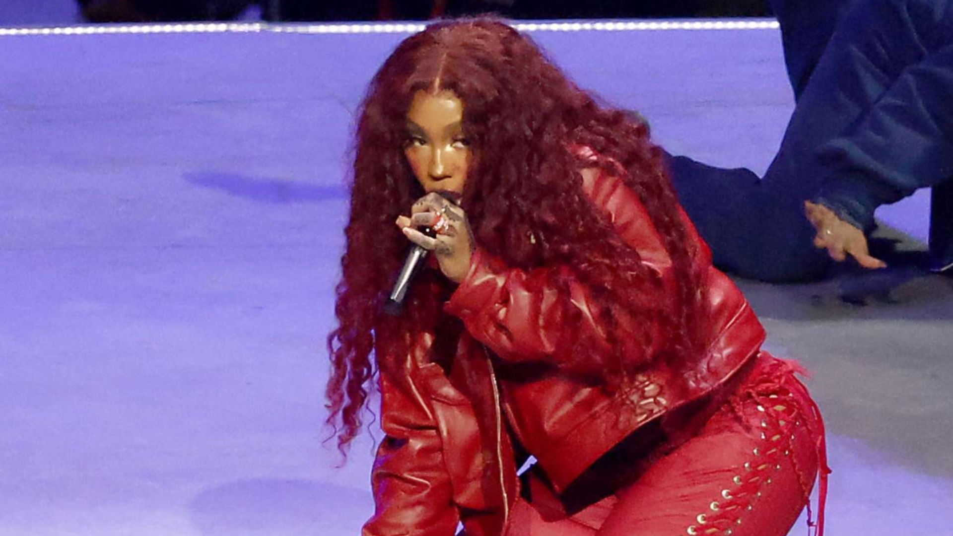 SZA showcases vibrant Super Bowl, exuding confidence and style on stage.