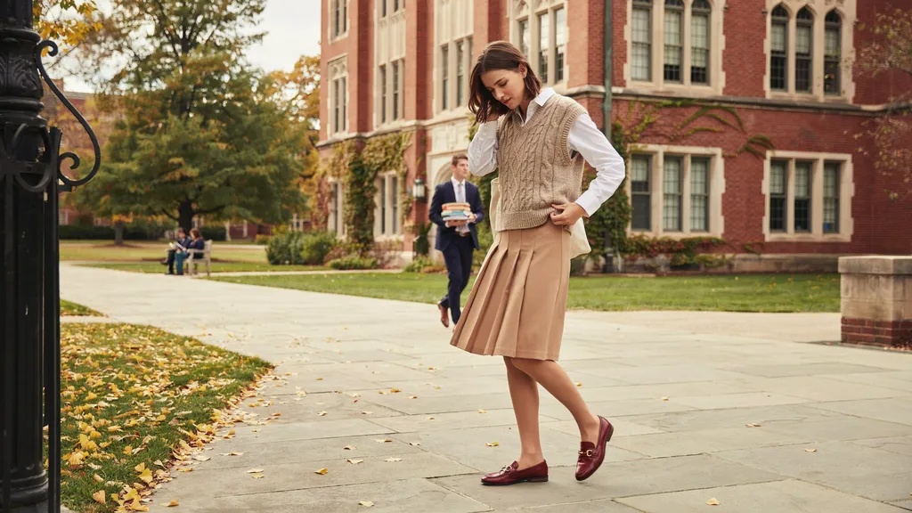Sweater vest layered over a button-down shirt in preppy style.