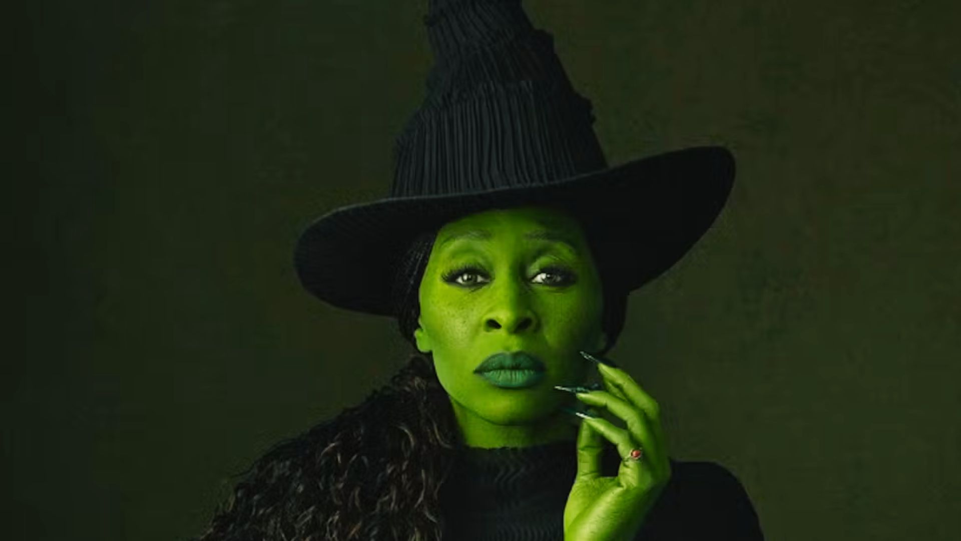Cynthia Erivo as Elphaba in Wicked, wearing dramatic witch hat and green makeup with intense expression.